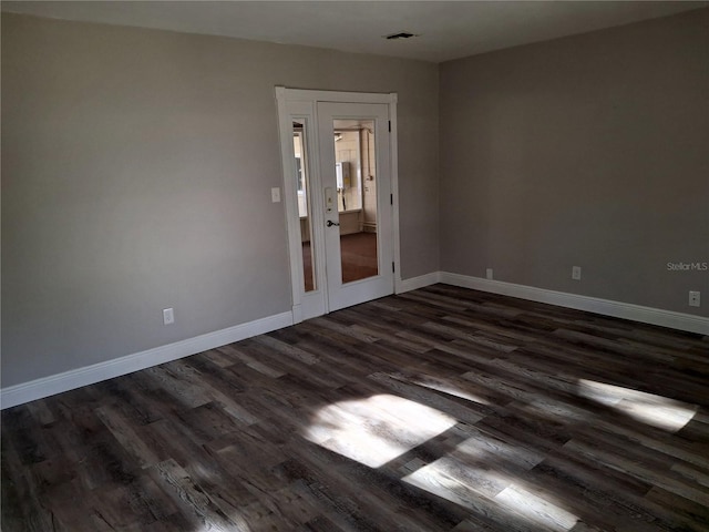 empty room with dark hardwood / wood-style flooring