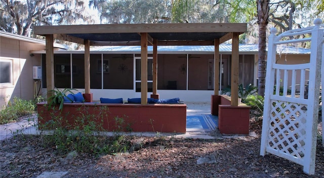 view of patio with a sunroom and a ceiling fan