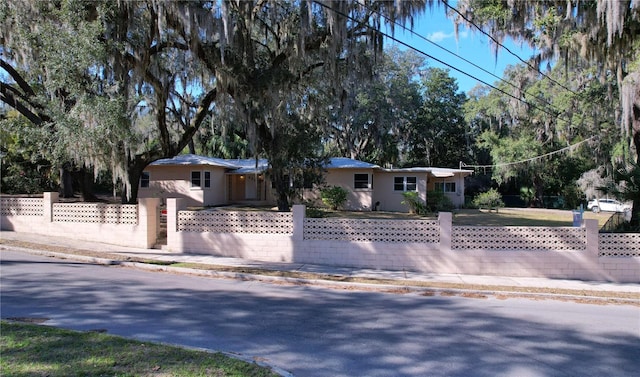 single story home with a fenced front yard and stucco siding