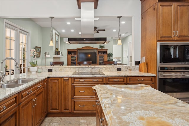 kitchen with decorative light fixtures, light stone countertops, and sink