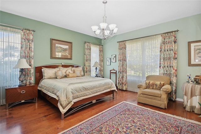 bedroom featuring wood-type flooring and a chandelier