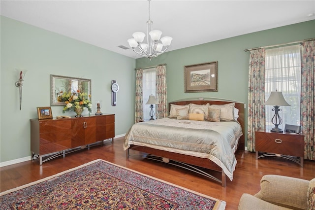 bedroom featuring dark wood-type flooring and an inviting chandelier