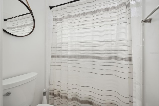 bathroom featuring a shower with shower curtain and toilet