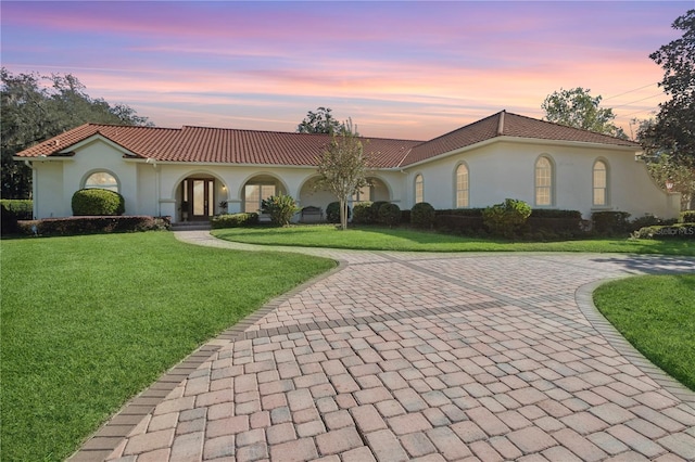 mediterranean / spanish home featuring a lawn