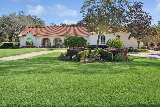 mediterranean / spanish-style house featuring a front yard