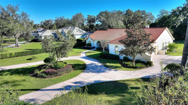 view of property's community with a garage and a lawn