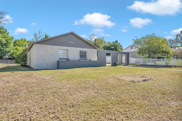 rear view of house featuring a yard