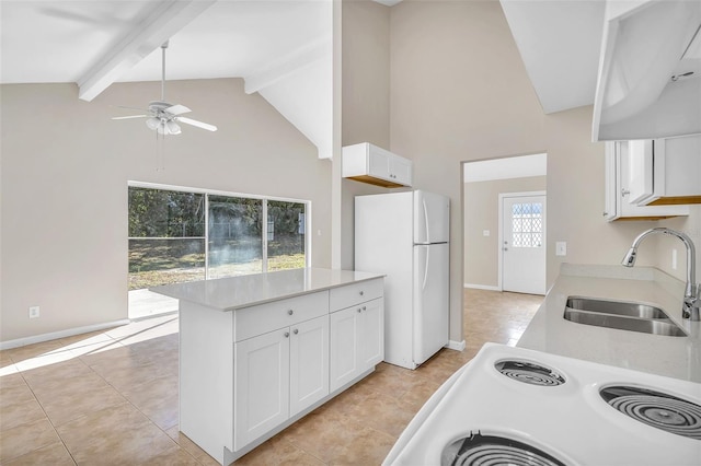 kitchen with white cabinets, sink, white fridge, beam ceiling, and range