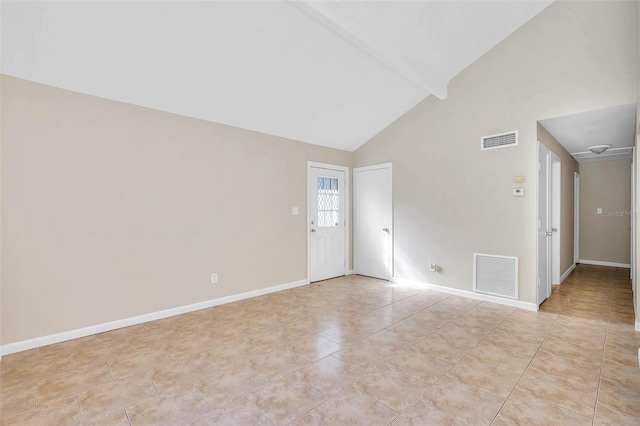 tiled empty room with beam ceiling and high vaulted ceiling