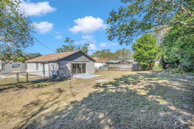 rear view of property with a yard and a patio area