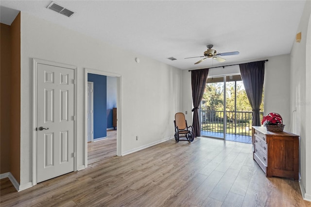 living area featuring light wood-type flooring and ceiling fan