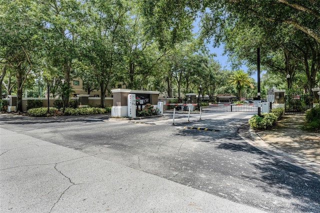 7135 Yacht Basin Ave Unit 237, Orlando, FL 32835 - view of asphalt road featuring a gate, curbs, and a gated entry