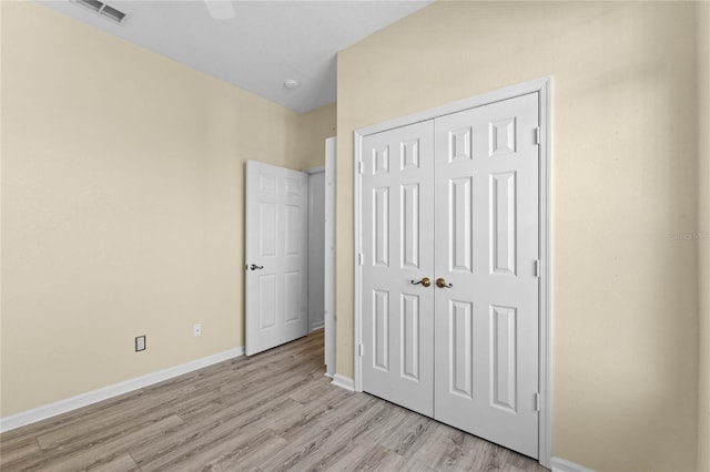 unfurnished bedroom with ceiling fan, a closet, and light hardwood / wood-style flooring