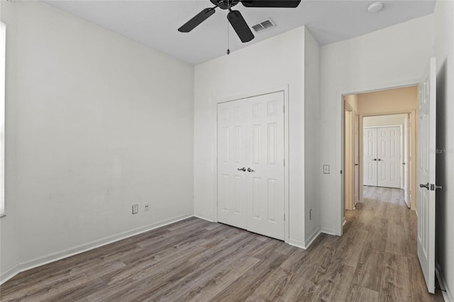 7135 Yacht Basin Ave Unit 237, Orlando, FL 32835 - unfurnished bedroom with wood finished floors, baseboards, a closet, and ceiling fan