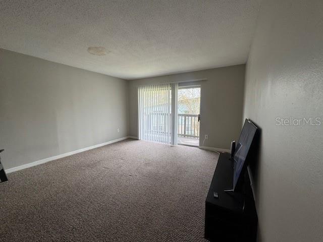 carpeted spare room with a textured ceiling