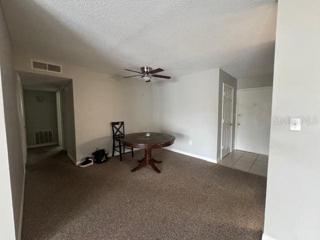 interior space with carpet flooring, a textured ceiling, and ceiling fan