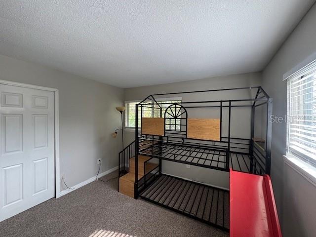 carpeted bedroom featuring a textured ceiling