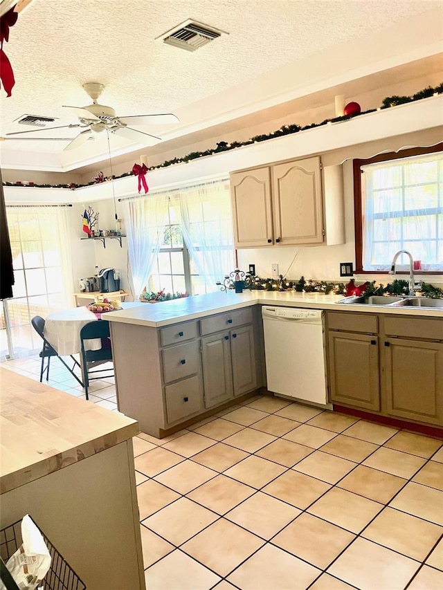 kitchen with dishwasher, sink, kitchen peninsula, and a textured ceiling