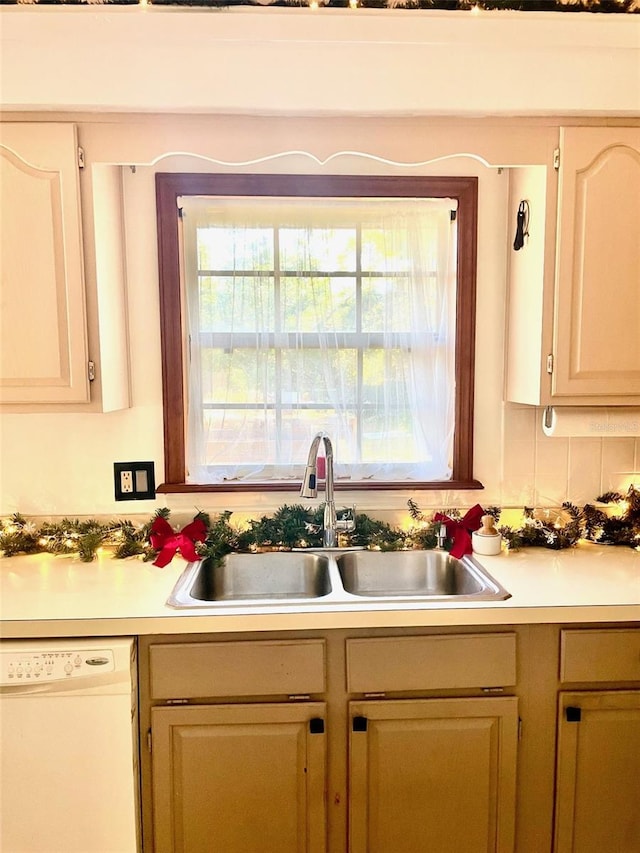 kitchen featuring light brown cabinetry, sink, and white dishwasher