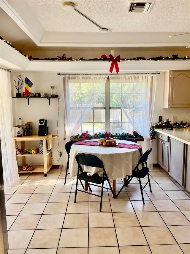 dining room featuring plenty of natural light, light tile patterned floors, and a textured ceiling