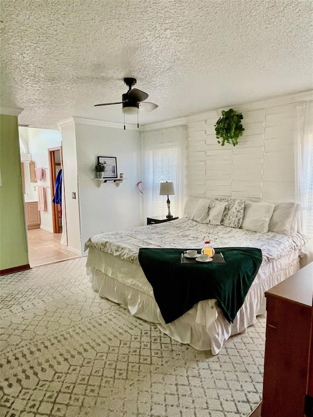 bedroom featuring a textured ceiling, connected bathroom, ceiling fan, and crown molding