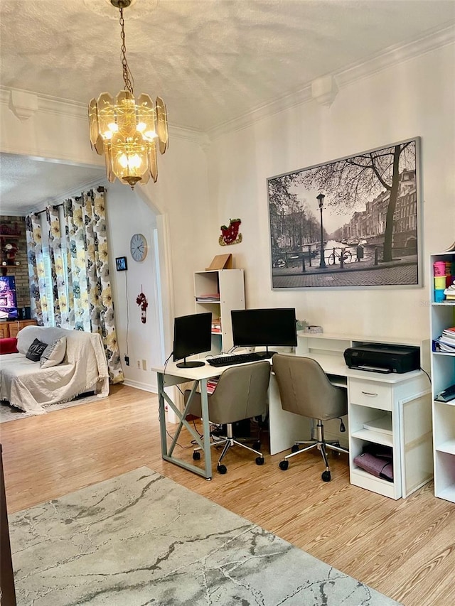 office with hardwood / wood-style floors, ornamental molding, and an inviting chandelier