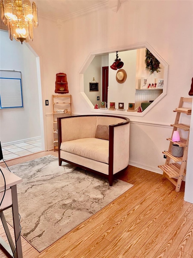 sitting room with a chandelier, light hardwood / wood-style flooring, and ornamental molding