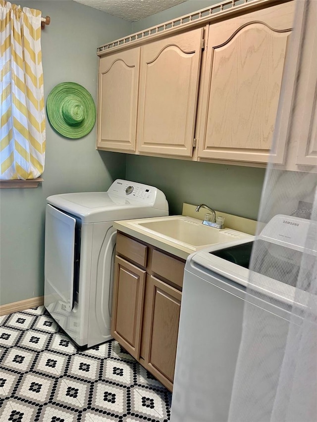 laundry room featuring cabinets, independent washer and dryer, and sink