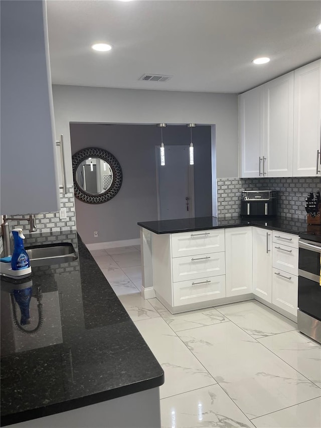 kitchen featuring kitchen peninsula, sink, white cabinetry, and stainless steel range oven