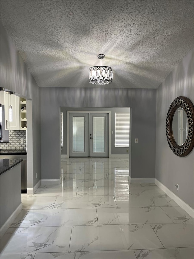 interior space featuring french doors and a textured ceiling