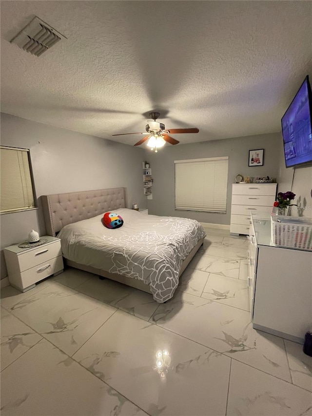 bedroom featuring ceiling fan and a textured ceiling