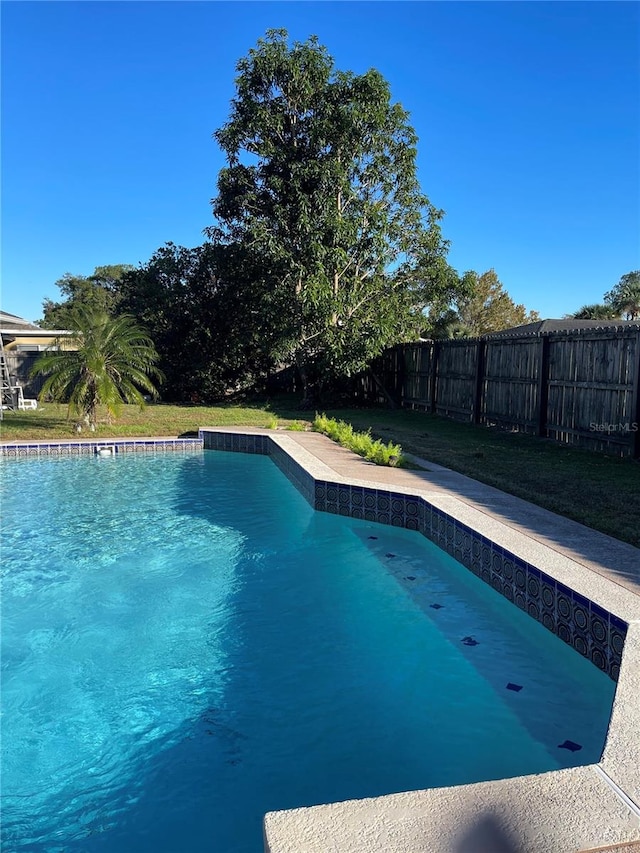 view of pool with a yard