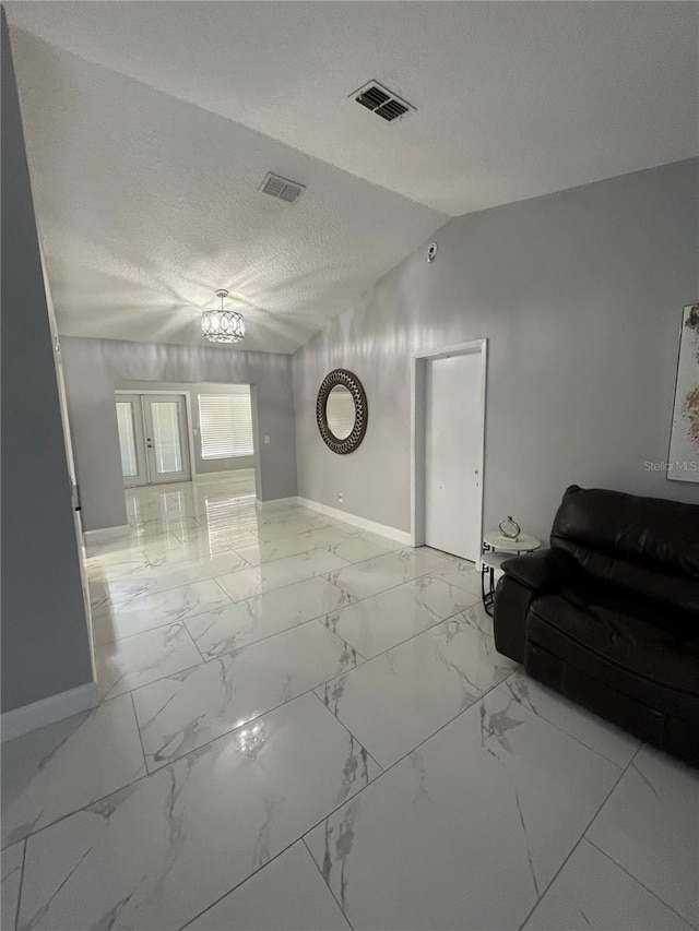 unfurnished living room featuring a chandelier, a textured ceiling, and vaulted ceiling