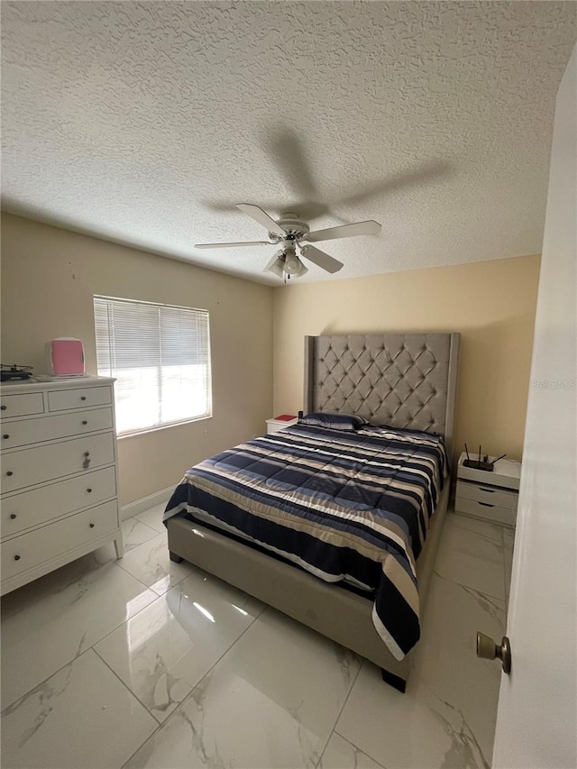 bedroom with ceiling fan and a textured ceiling