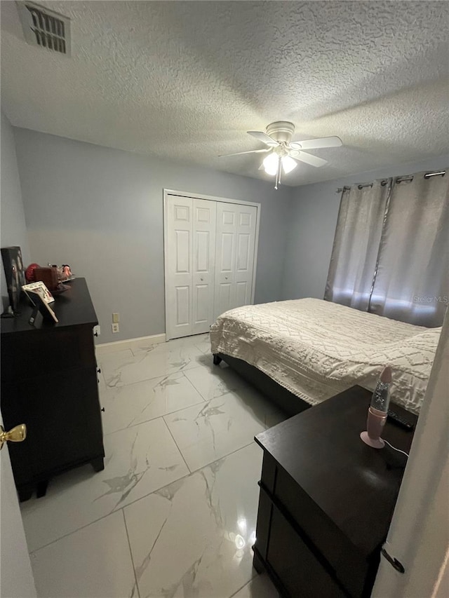 bedroom with ceiling fan, a closet, and a textured ceiling