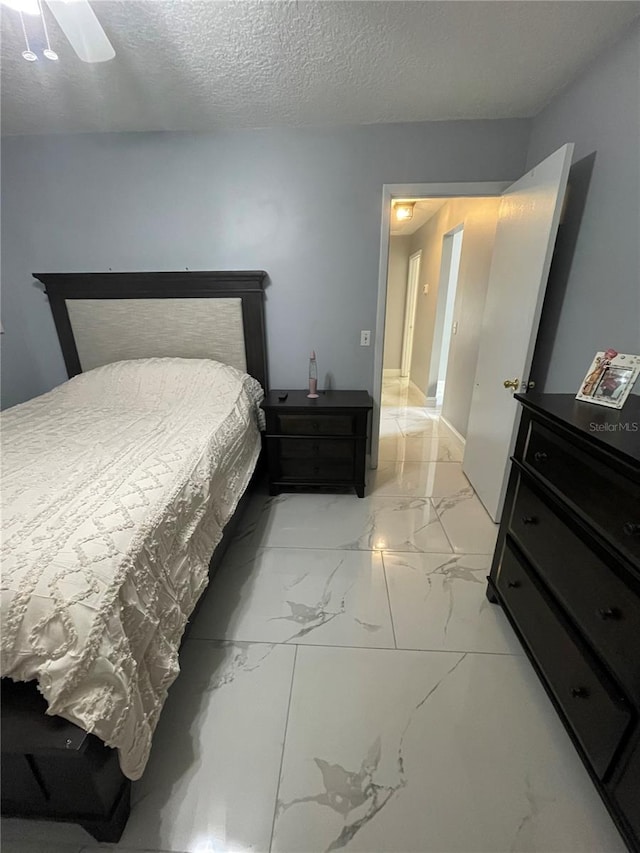 bedroom featuring ceiling fan and a textured ceiling