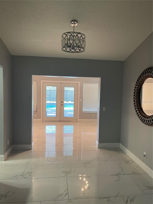 entryway with a textured ceiling and french doors