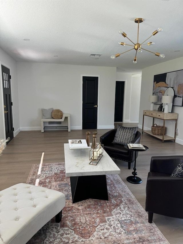 living room featuring hardwood / wood-style floors, a notable chandelier, and a textured ceiling