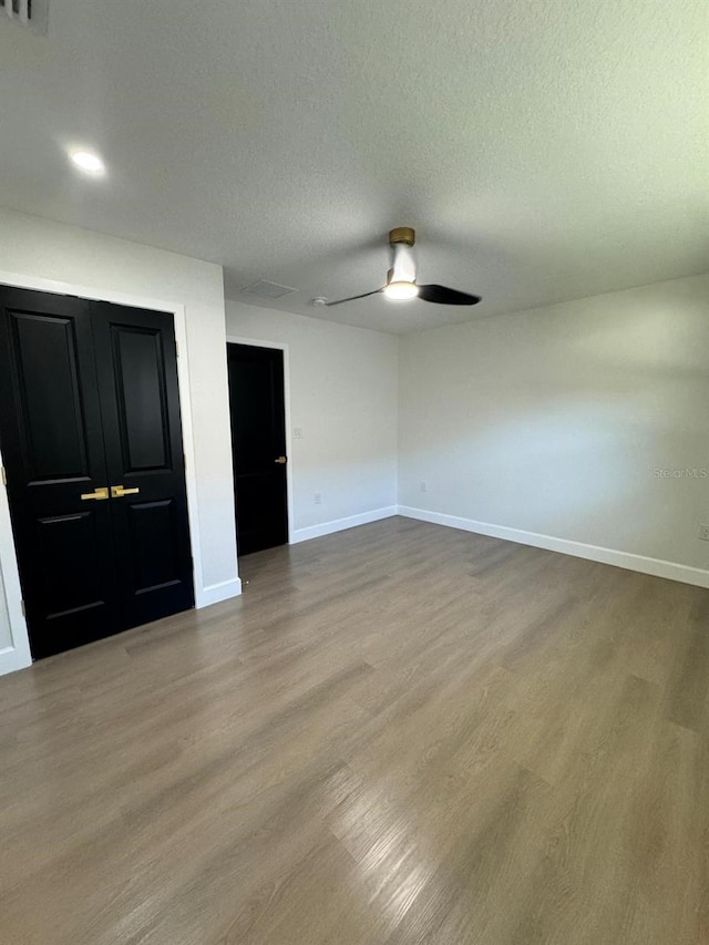 unfurnished bedroom with ceiling fan, light hardwood / wood-style flooring, and a textured ceiling