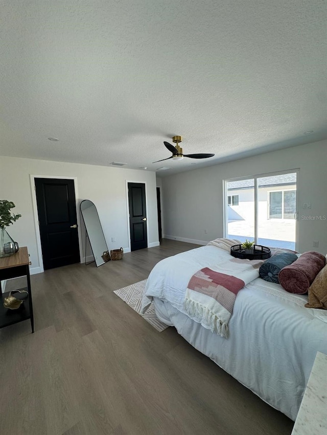 bedroom featuring ceiling fan, wood-type flooring, and a textured ceiling