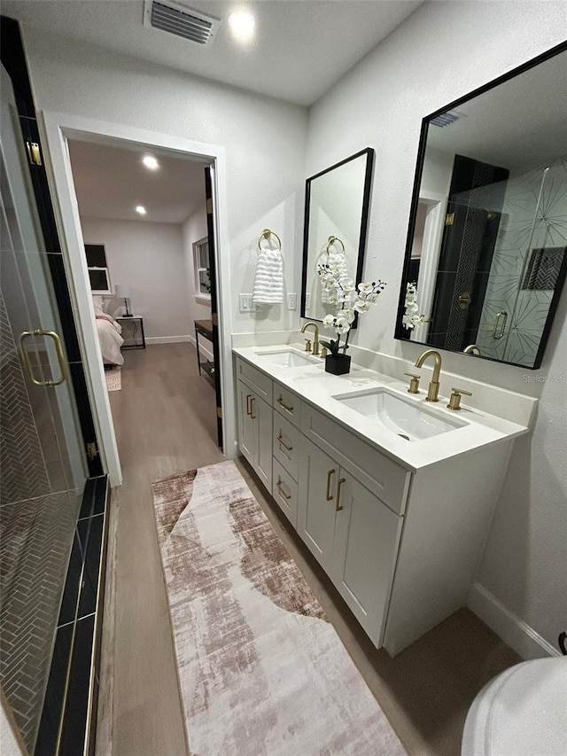 bathroom featuring wood-type flooring, vanity, and walk in shower