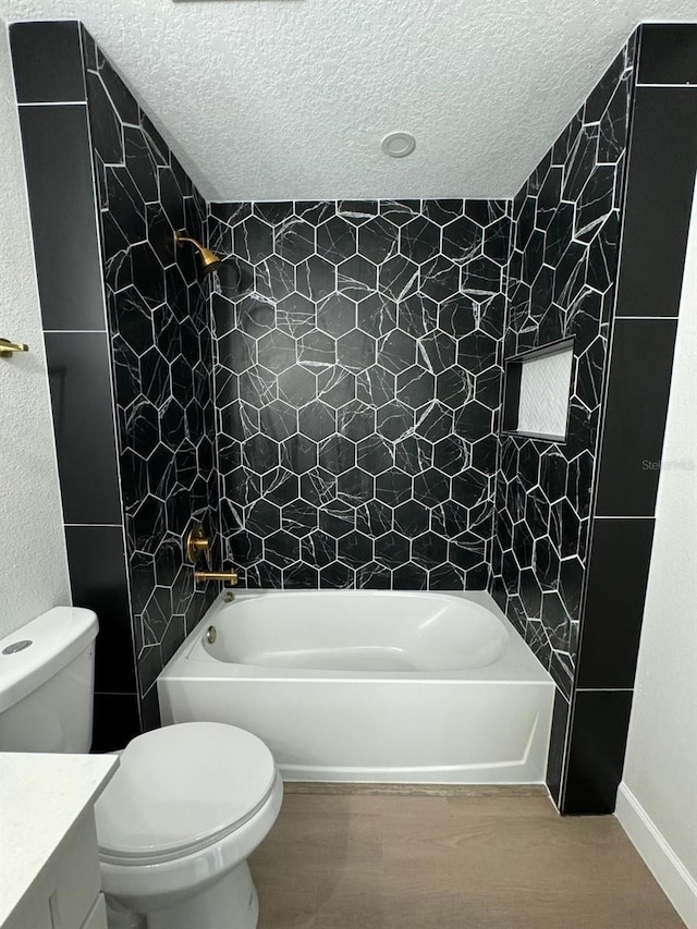 full bathroom with tiled shower / bath combo, a textured ceiling, and toilet