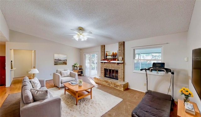 carpeted living room with a textured ceiling, ceiling fan, lofted ceiling, and a fireplace