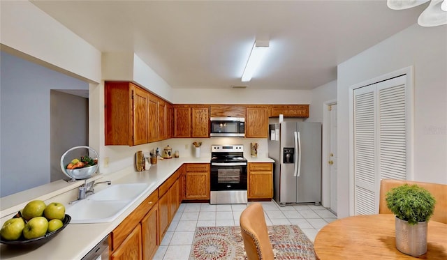 kitchen featuring light tile patterned flooring, stainless steel appliances, and sink