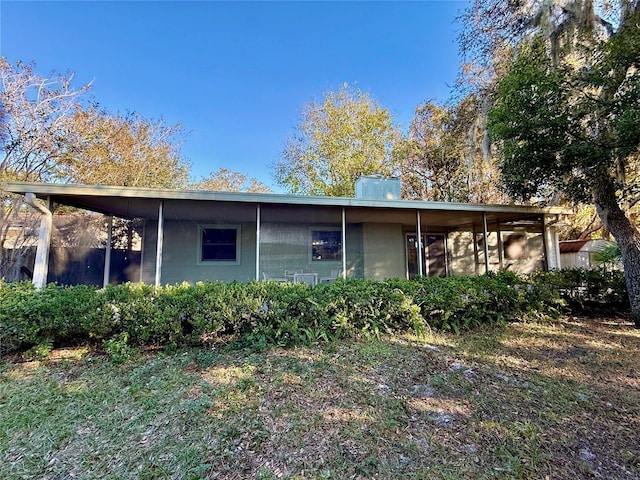 back of house featuring a carport