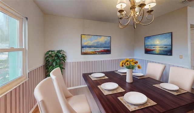 dining space with a notable chandelier and a textured ceiling