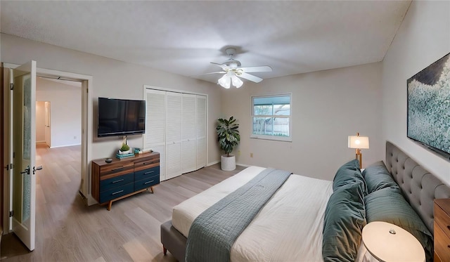 bedroom with light hardwood / wood-style flooring, a closet, and ceiling fan