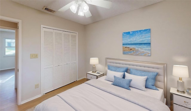 bedroom with ceiling fan, a textured ceiling, a closet, and light wood-type flooring