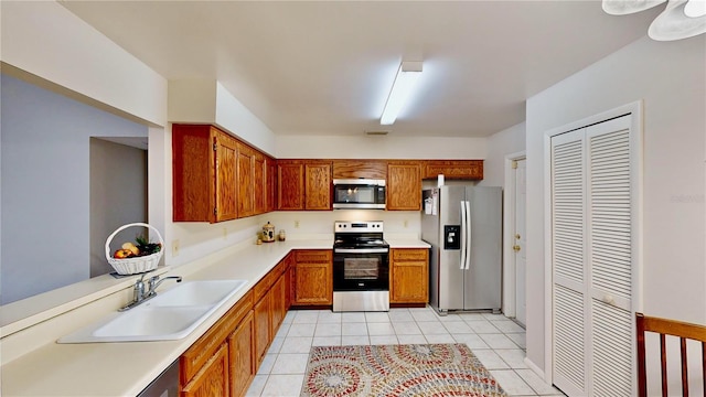 kitchen featuring sink, light tile patterned floors, and appliances with stainless steel finishes