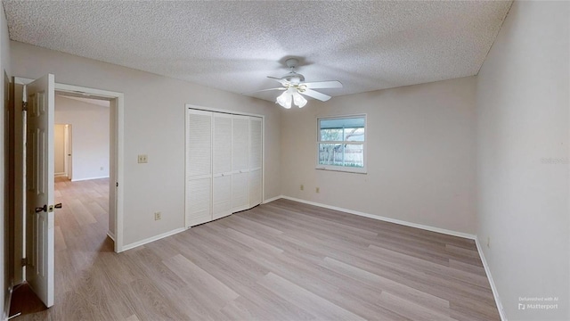 unfurnished bedroom featuring a closet, ceiling fan, a textured ceiling, and light hardwood / wood-style flooring